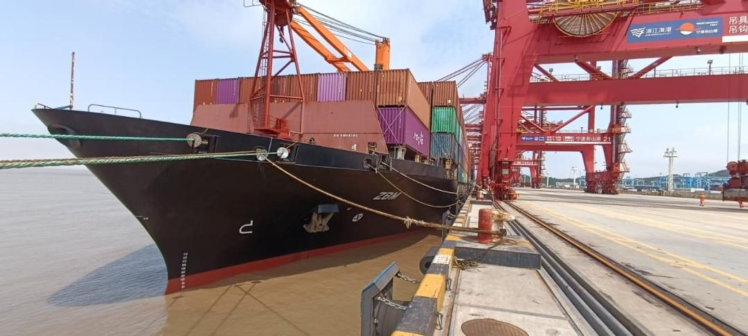 Container vessel MV ZBM berthed with cargo containers and port gantry cranes